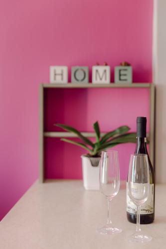 a bottle of wine and two wine glasses on a table at Casa di Mema in Argostoli