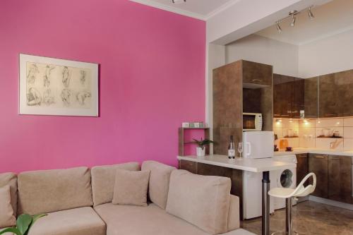 a living room with a couch and a pink wall at Casa di Mema in Argostoli