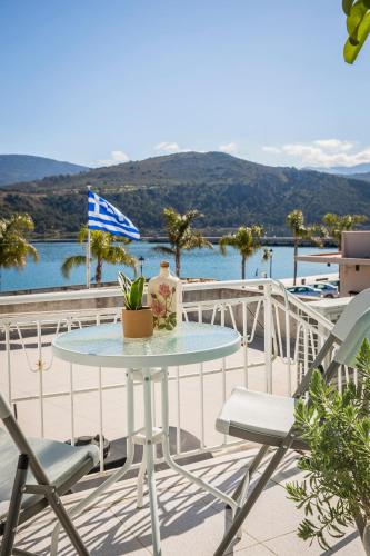 a table and chairs on a balcony with a view of the water at Casa di Mema in Argostoli