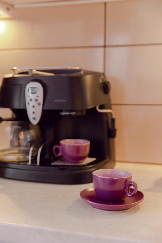a coffee maker with two cups on a counter at Casa di Mema in Argostoli