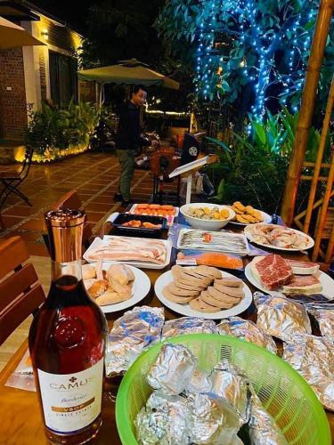 a table filled with food and a bottle of wine at Tam Coc Golden Rice in Ninh Binh