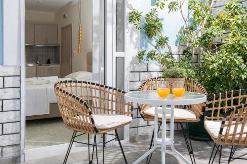 a patio with a table and chairs with orange juice at Ninemia Studios in Limenas