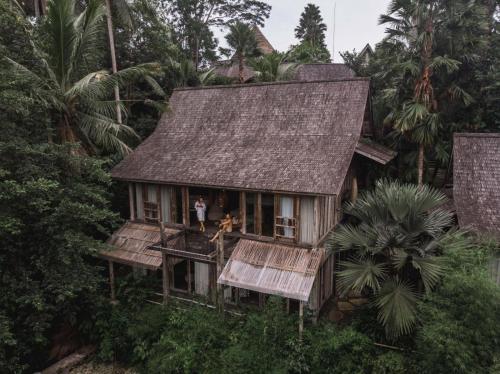 a man standing on the balcony of a house at Blue Karma Dijiwa Ubud in Ubud