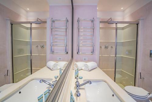 bagno con vasca, servizi igienici e specchi. di Ca' Grassi 2 Charming Balcony a Venezia