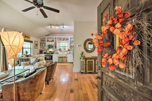 a dining room and living room with a wreath on a wall at Enchanting Whitney Cabin with Beach and Creek! in Diamondhead