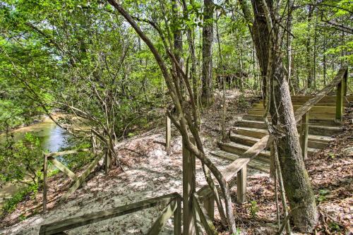a set of stairs in the woods with a fence at Enchanting Whitney Cabin with Beach and Creek! in Diamondhead