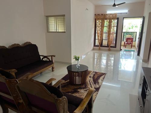 ein Wohnzimmer mit einem Sofa und einem Tisch in der Unterkunft Athrakkattu Enclave in Thiruvananthapuram