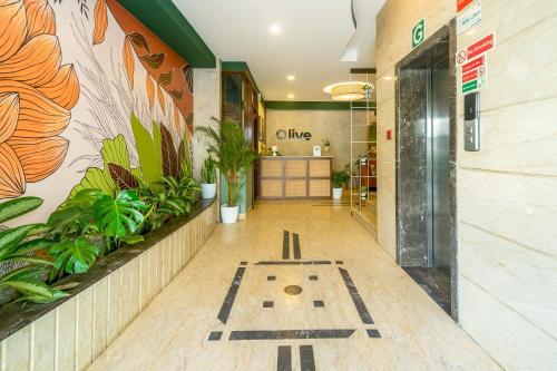 a lobby of a clinic with plants on the wall at Olive Rest House Road by Embassy Group in Bangalore