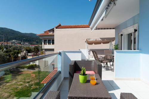 a balcony of a house with a table and chairs at Ninemia Studios in Limenas