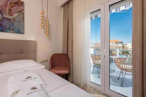 a hotel room with a bed and a balcony at Ninemia Studios in Limenas