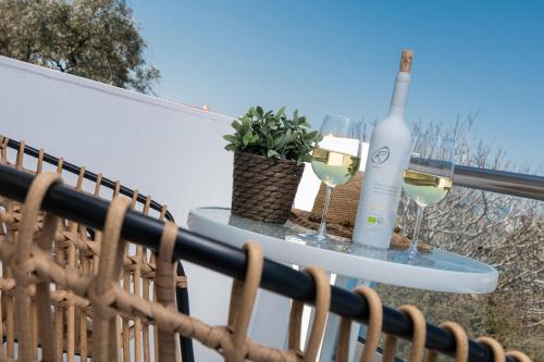 a bottle of wine and glasses on a table on a balcony at Ninemia Studios in Limenas