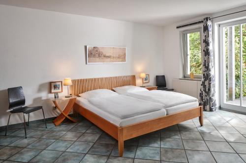 a bedroom with a bed and a desk and a chair at Ferienwohnungen Haus am Deich in Prerow