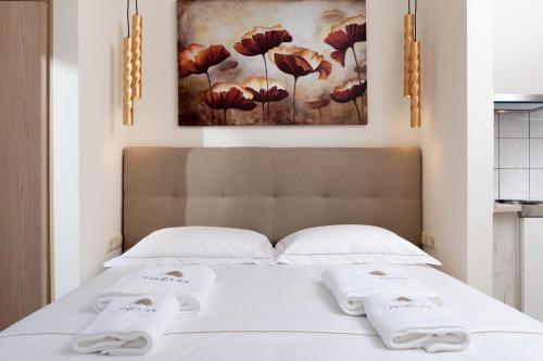 a bedroom with a bed with two towels on it at Ninemia Studios in Limenas