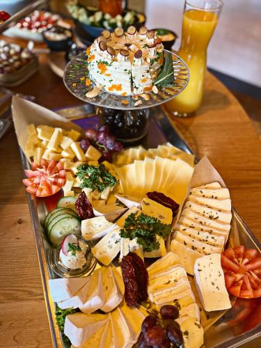 a tray of cheese and other appetizers on a table at Boutique Hotel Lindenhof, Bed & Breakfast in Aurich