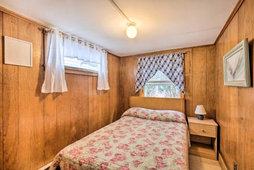 a small bedroom with a bed and a window at No-Frills Hampton Cottage - Steps to Beach! in Hampton
