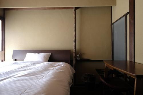 a bedroom with a bed and a desk and a table at UNKNOWN KYOTO in Kyoto