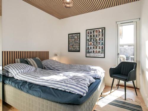 een slaapkamer met een bed, een stoel en een raam bij Holiday home Otterup XXX in Otterup
