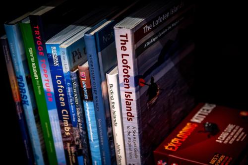 a row of books sitting on a shelf at Været - Your Lofoten Basecamp in Henningsvær