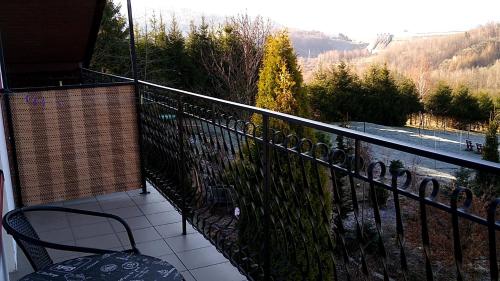 a balcony with a chair and a view of the mountains at Dom Wschodzącego Słońca in Solina
