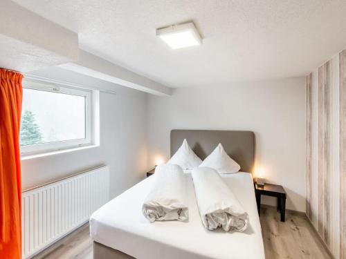 a bedroom with a bed with white sheets and a window at Apartment in Sankt Gallenkirch near Ski Slopes in Sankt Gallenkirch