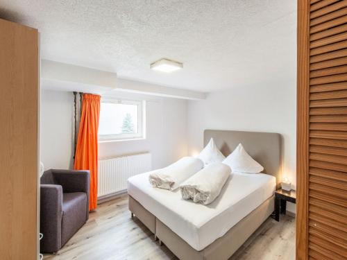 a bedroom with a bed and a chair and a window at Apartment in Sankt Gallenkirch near Ski Slopes in Sankt Gallenkirch