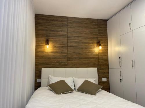 a bedroom with a white bed with two pillows at מול הים בקיסריה1 in Caesarea