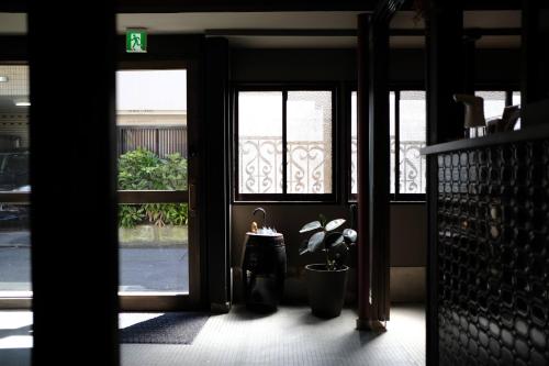 a hallway with doors and a potted plant and a window at UNKNOWN KYOTO in Kyoto
