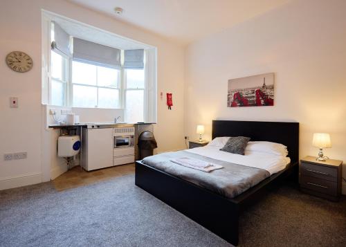 a bedroom with a bed and a sink and a window at OYO Studiotel Hartlepool in Hartlepool