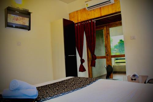 a bedroom with a bed and a door with a window at Rainwood Residency in Lonavala