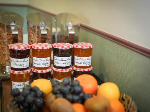 a group of jars of jam on a table with fruit at Hôtel Mount Venturi - Aix-En-Provence Sainte-Victoire - Bar & Restaurant & Padel in Rousset