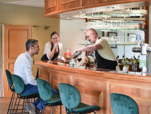 a group of men sitting at a bar at Hôtel Mount Venturi - Aix-En-Provence Sainte-Victoire - Bar & Restaurant & Padel in Rousset