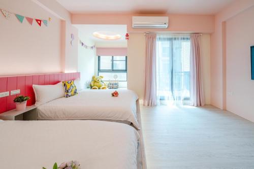 五結鄉的住宿－漫漫時光民宿，配有粉红色墙壁的客房内的两张床