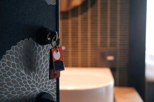 a key chain on a door with a toilet at UNKNOWN KYOTO in Kyoto