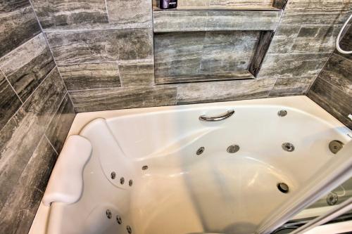 a white bath tub in a bathroom with a tile wall at Torrey Spa Suite Modern San Diego Studio! in San Diego