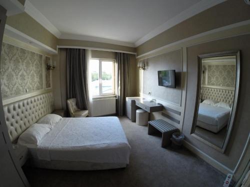 Pokój hotelowy z łóżkiem i lustrem w obiekcie deniz otel w Stambule