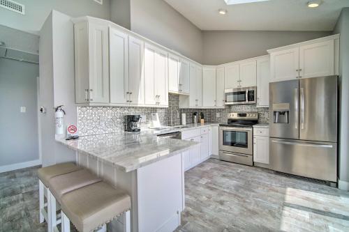 a kitchen with white cabinets and stainless steel appliances at Condo with Bay Views about 5 Mi to Atlantic City! in Brigantine