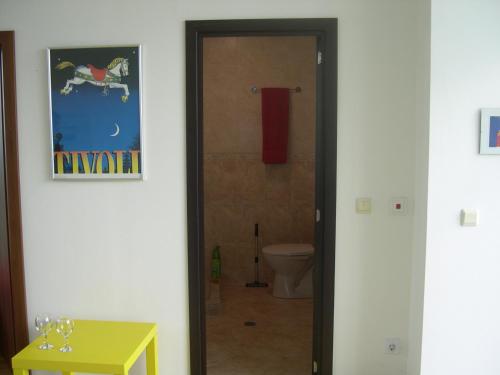 ein Bad mit einer Tür, die zu einem WC führt in der Unterkunft Sea view, 2 room apartment 703, Primorsko in Primorsko
