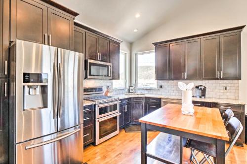 a kitchen with a stainless steel refrigerator and a wooden table at Alma Retreat with Mtn Views about 17 Mi to Breck! in Alma