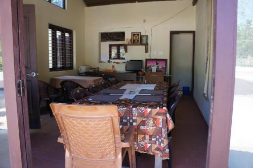 un comedor con una mesa larga y sillas en Raj Estate Stay en Madikeri