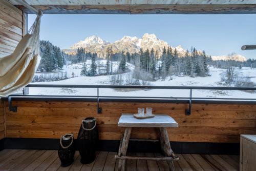 a wooden table in front of a window with a view of mountains at mama thresl in Leogang