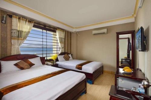 ein Hotelzimmer mit 2 Betten und einem Fenster in der Unterkunft VINH MINH HOTEL in Nha Trang