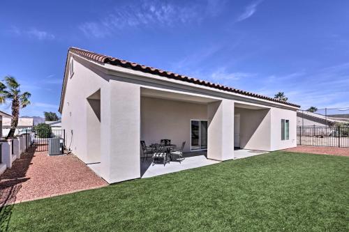 a white house with a large yard at Bright Home with Yard, 4 Mi to Colorado River! in Fort Mohave