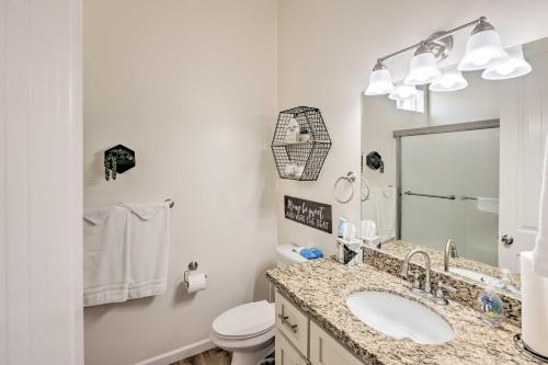 a bathroom with a sink and a toilet and a mirror at Bright Home with Yard, 4 Mi to Colorado River! in Fort Mohave