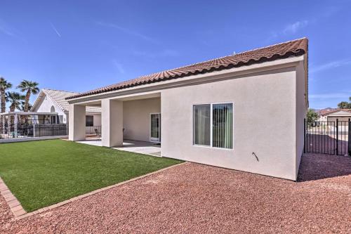 a white house with a large garage at Bright Home with Yard, 4 Mi to Colorado River! in Fort Mohave
