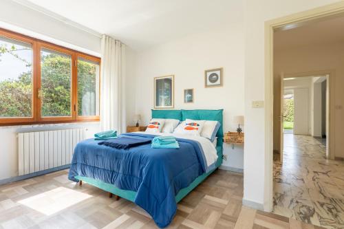 Schlafzimmer mit einem Bett mit blauer Decke in der Unterkunft Villa Le Maree di Tonfano in Pietrasanta