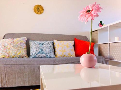a living room with a couch and a vase with a flower at The Summer Treat Shared Apartment Compartido in Corralejo