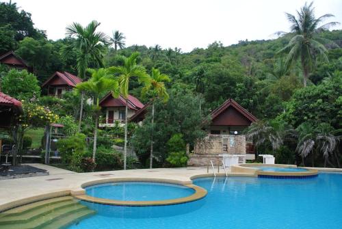 two swimming pools in front of a resort at Tanouy Garden in Baan Khai