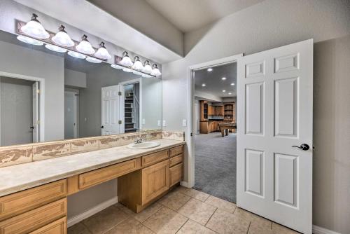 Un baño con lavabo y un espejo grande. en Estate with Indoor Pool and Decks about 25 Mi to Dtwn, en Colorado Springs