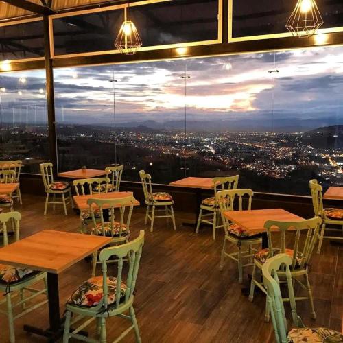 a restaurant with tables and chairs and a view at Hotel Entre Lomas in Santa Rosa de Cabal