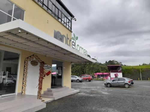a car dealership with cars parked in a parking lot at Hotel Entre Lomas in Santa Rosa de Cabal